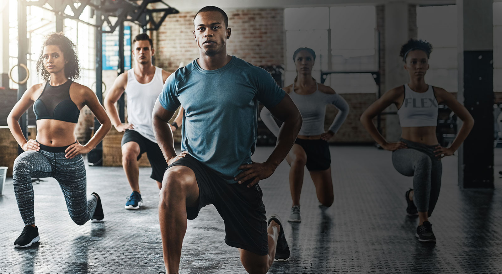 Five adults in gym fitness class
